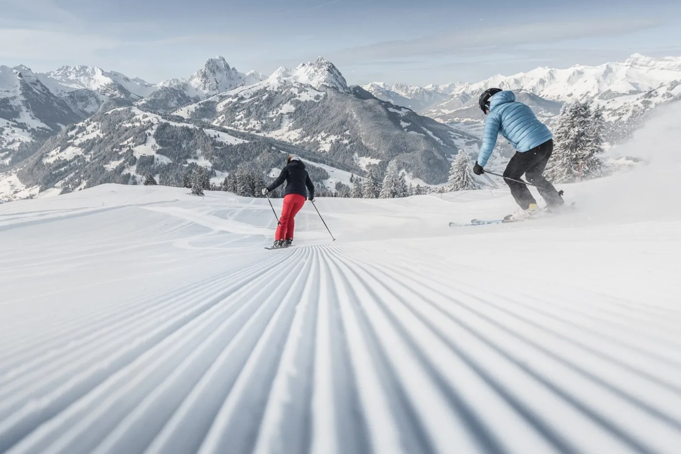 Skiers descending a groomed slope in Gstaad